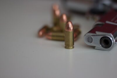 Photo by Enrico Hänel: https://www.pexels.com/photo/close-up-of-bullet-beside-a-gun-5462023/