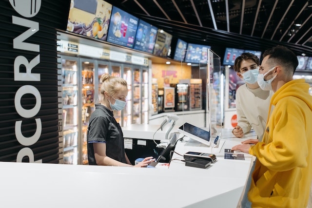 Photo by Pavel Danilyuk: https://www.pexels.com/photo/two-men-standing-in-front-of-a-cashier-of-a-movie-theater-7234474/